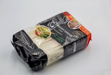 Kyiv, Ukrayna - 21 Aralık 2024: Siyah ambalajlı ve kırmızı aksanlı ambalajlı pirinç eriştesi, şeffaf porsiyon yoluyla görünen beyaz düz erişteleri gösteriyor, pişirme önerileriyle etiketlenmiş yiyecekleri gösteriyor.