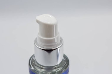 Tarafsız arkaplanda temiz beyaz bir şeker kutusuyla kozmetik bir pompa şişesinin yakın çekimi. Fotokopi alanı olan soyut minimal cilt ya da güzellik ürünü kavramı, markalaşma ve reklam için uygundur..