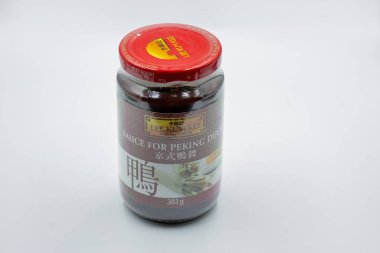 Kyiv, Ukrayna - 8 Şubat 2025: Lee Kum Kee sosu cam kavanozda kırmızı vida kapaklı Pekin ördeği. Koyu kahverengi sos geleneksel ördek hazırlıklarını gösteren Çince ve İngilizce etiketleme içerir..