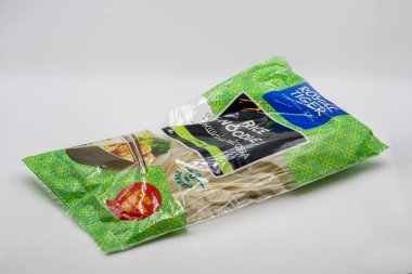 Kyiv, Ukrayna - 16 Mart 2025: Açık yeşil ambalajlı, şeffaf pencereli, beyaz erişteli Royal Tiger pirinç eriştesi paketi. Beyaz arkaplanda Asya gıda ürünleri ambalajı.