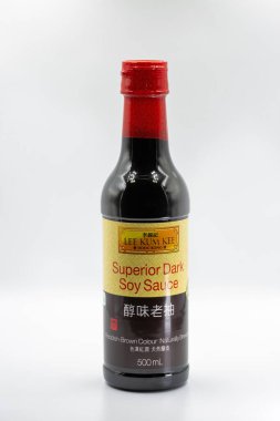 Kyiv, Ukrayna - 23 Mart 2025: Lee Kum Kee Superior Koyu Soya soslu kırmızı şapkalı şişe. Hong Kong markalı koyu soya sosu. Beyaz üzerine yakın plan kırmızı kahve rengi..