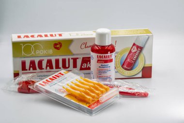 Kyiv, Ukrayna - 22 Aralık 2025: Lacalut Aktiv diş macunu çözücü şişesi, diş macunu tüpü ve ürün ambalajıyla düzenlenmiş diş fırçaları, 100 yıllık yıldönümü kutlamaları.