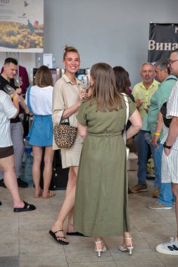 Kyiv, Ukrayna - 07 Haziran 2025: Şarap tatma kabini. İnsanlar, üzüm bağı imgeleri ve aile şarabı geleneği hakkında yazılar içeren tanıtım pankartlarıyla sergileniyor..