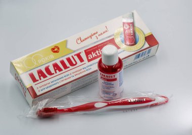 Kyiv, Ukrayna - 22 Aralık 2025: Lacalut Aktiv diş macunu çözücü şişesi, diş macunu tüpü ve ürün ambalajıyla düzenlenmiş diş fırçaları, 100 yıllık yıldönümü kutlamaları.