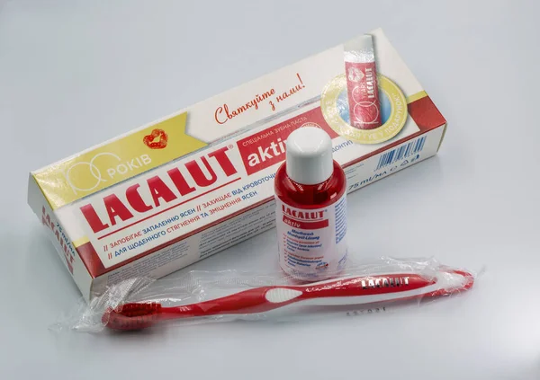 Kyiv, Ukrayna - 22 Aralık 2025: Lacalut Aktiv diş macunu çözücü şişesi, diş macunu tüpü ve ürün ambalajıyla düzenlenmiş diş fırçaları, 100 yıllık yıldönümü kutlamaları.