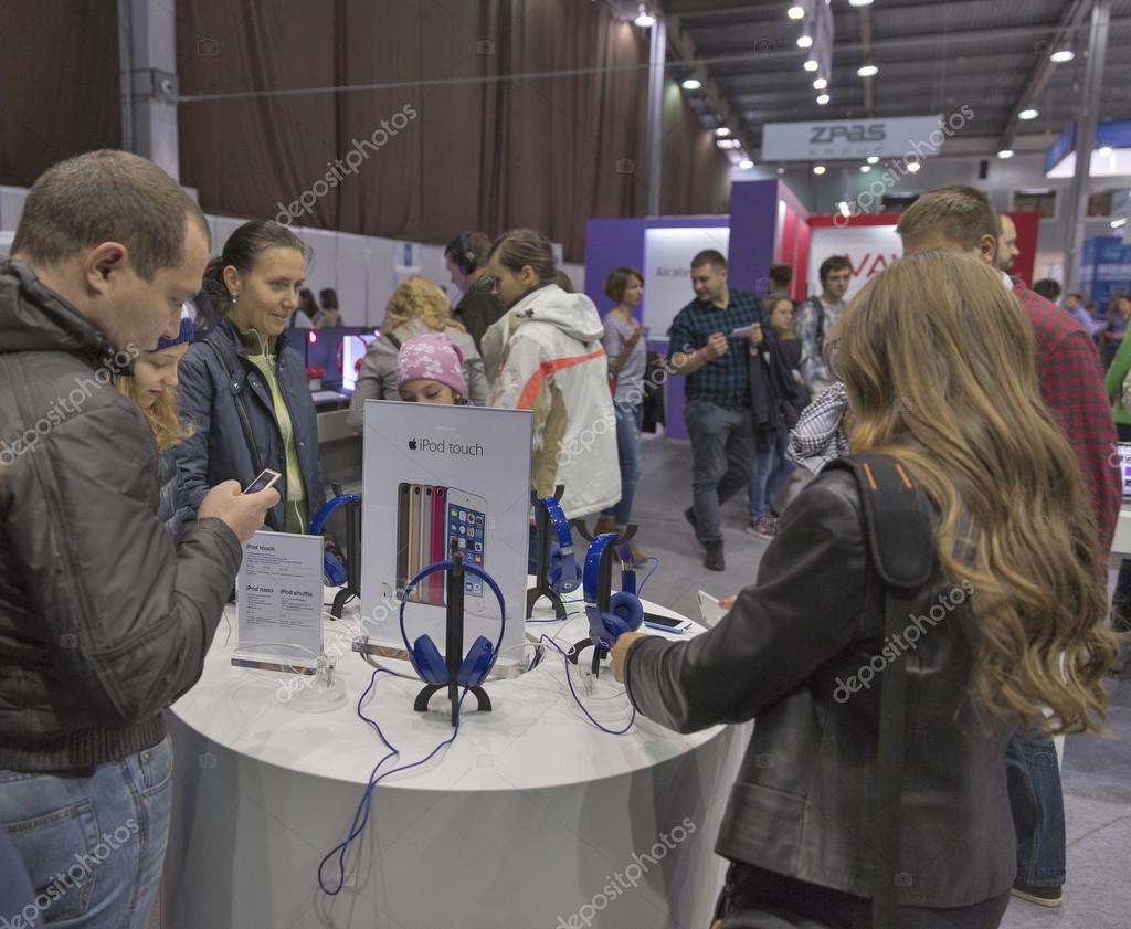KIEV, UKRAINE - OCTOBER 11, 2015: People visit Apple, an American multinational technology company booth during CEE 2015, the largest electronics trade show of Ukraine in ExpoPlaza Exhibition Center.