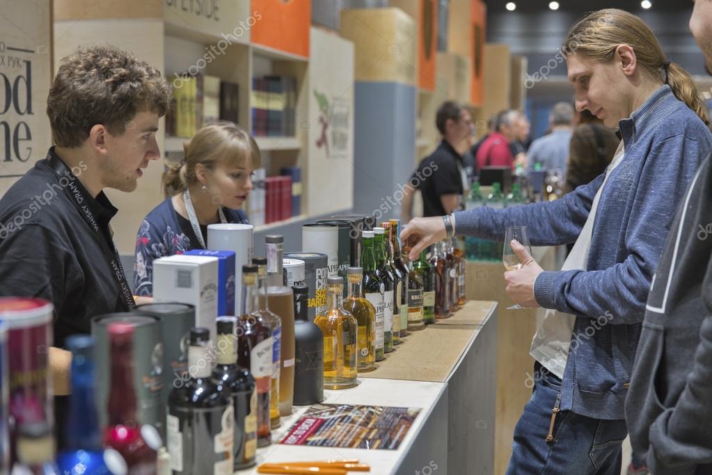 KIEV, UKRAINE - NOVEMBER 21, 2015: Unrecognized people visit Good Wine Highland and Speyside Single Malt Scotch Whiskey booth at 1st Ukrainian Whisky Dram Festival in Parkovy Exhibition Center.