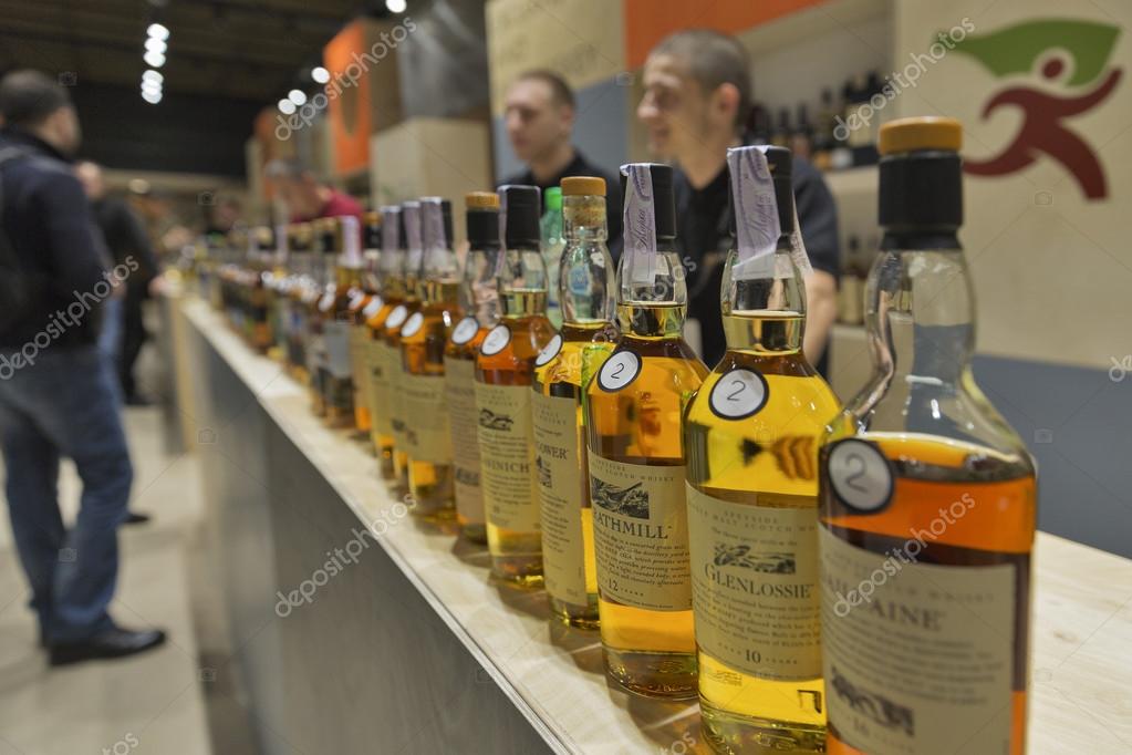KIEV, UKRAINE - NOVEMBER 21, 2015: Unrecognized presenters work on Good Wine Exclusive and Rare Single Malt Scotch Whiskey booth at 1st Ukrainian Whisky Dram Festival in Parkovy Exhibition Center.