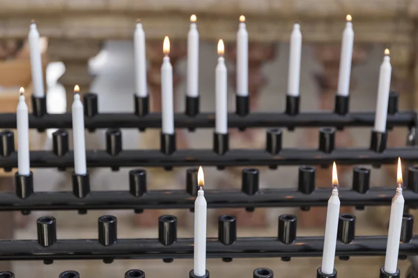 Candles in cathedral - religion background, focus on foreground — Stock Photo, Image