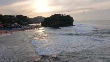 Sakin, dalgalı beyaz bir kumsalın siluet videosu.