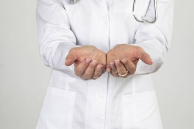 Kadın doktor elinde boş avuçlar sunuyor. Elinde fotokopi alanı için bir şey tutuyor. Beyaz üzerine izole edilmiş yakın plan konsept.