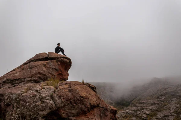 Silhueta de um homem mytieriuos que está no topo da montanha inbetgween a névoa — Fotografia de Stock