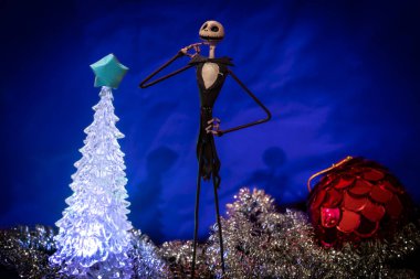 Noel Gecesi 'nden Büyüleyici Jack Skellington mavi arka planda şenlikli süslerle çevrili.