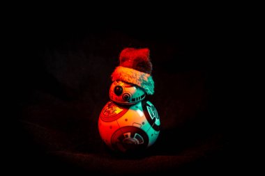 Yıldız Savaşları 'ndan kalma sevimli droid BB-8, koyu arkaplanda renkli ışıklarla aydınlatılmış bir Noel şapkası takıyor.