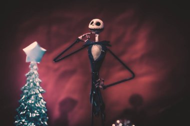 Noel Gecesi 'nden Büyüleyici Jack Skellington kırmızı arka planda şenlikli süslerle çevrili.
