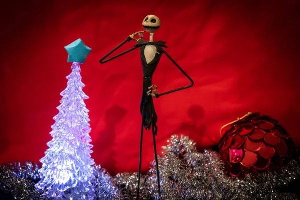 Noel Gecesi 'nden Büyüleyici Jack Skellington kırmızı arka planda şenlikli süslerle çevrili.