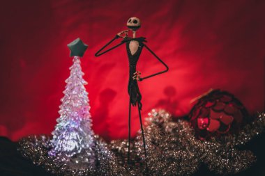 Noel Gecesi 'nden Büyüleyici Jack Skellington kırmızı arka planda şenlikli süslerle çevrili.
