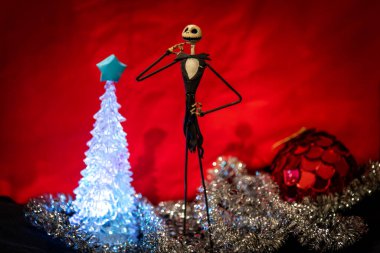Noel Gecesi 'nden Büyüleyici Jack Skellington kırmızı arka planda şenlikli süslerle çevrili.