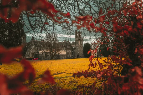 Fort AUGUSTUS, SCOTLAND, 17 Aralık 2018: Abbey Highland Kulüp saat kulesi ve bahçesi, ağaçların arasında, arka planda dağlar olan yoğun bulutların altında,.