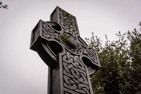 Meravigliosa croce in pietra celtica goffrata, ricca di dettagli e texture nelle sue elaborate sculture e nella coltivazione di licheni. — Foto Stock