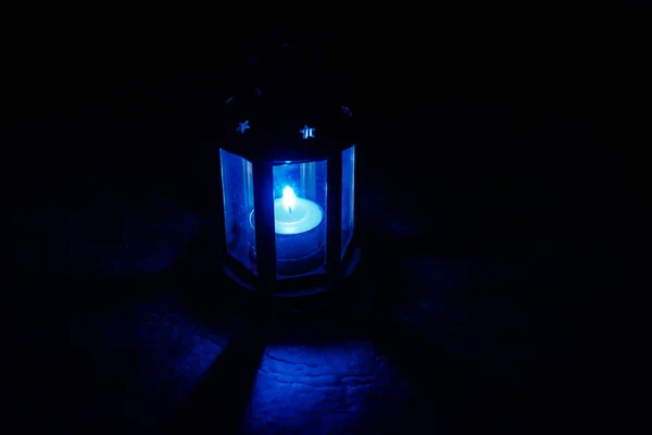 Lâmpada de vela mágica assustadora com buracos em forma de estrela brilhando de dentro. Iluminando vagamente o chão e projetando sombras — Fotografia de Stock