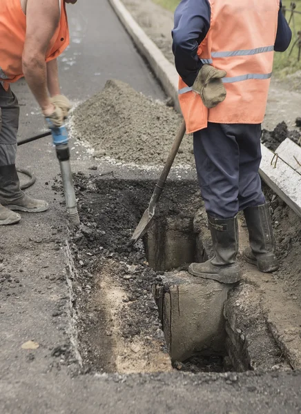 Vägbeläggning. Arbetstagare om sten gjutasfalt under gatan r — Stockfoto