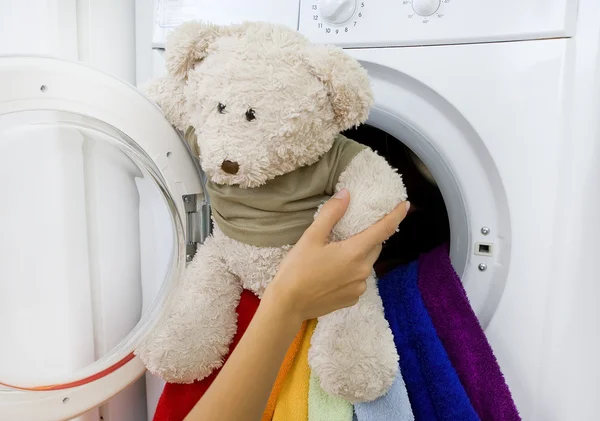 Mulher tomando brinquedo fofo da máquina de lavar roupa — Fotografia de Stock