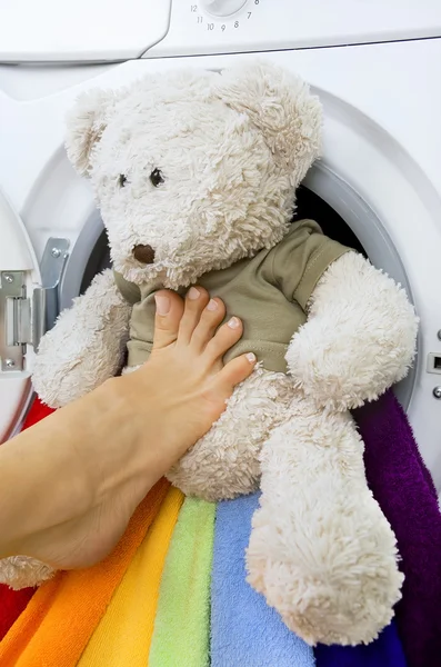 Woman loading fluffy toy in the washing machine — Stock Photo, Image