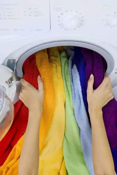 Vrouw die kleur kleding van wasmachine — Stockfoto