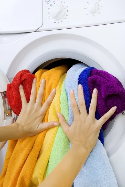 Mulher carregando roupas na máquina de lavar roupa — Fotografia de Stock