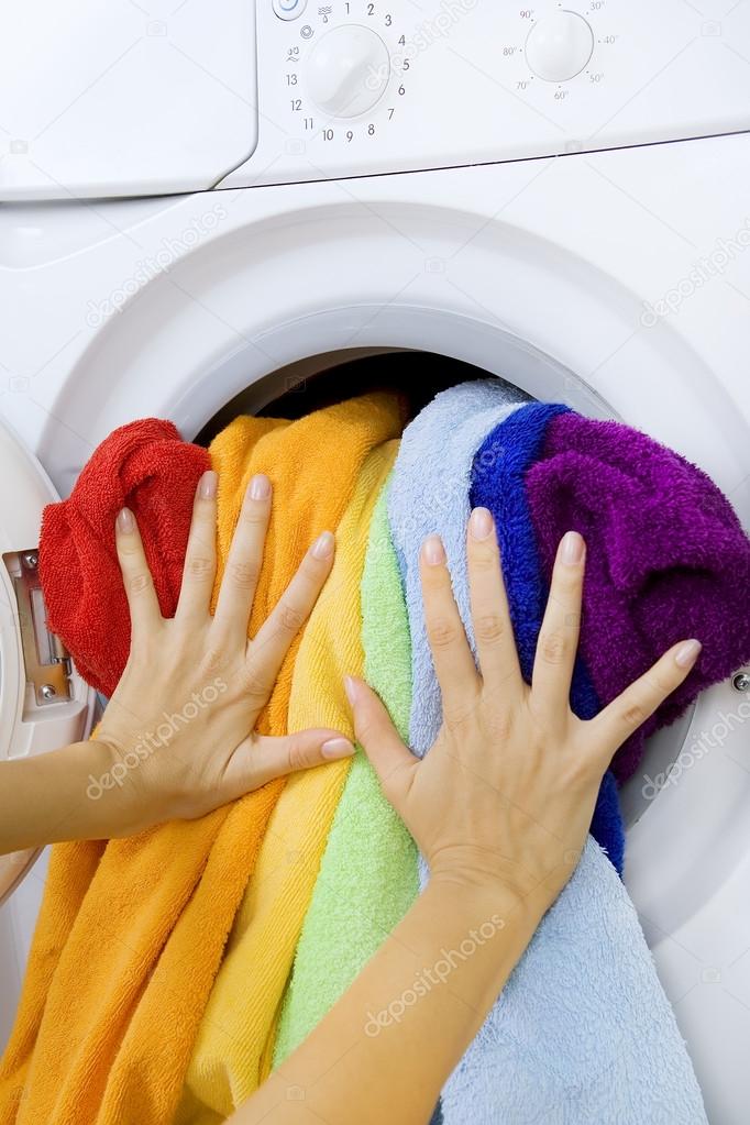 Woman loading clothes in the washing machine