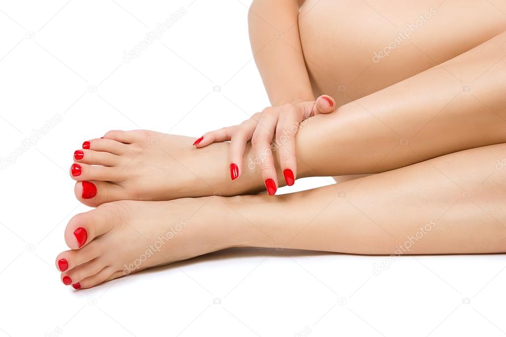 female foots with red pedicure and hands with red manicure