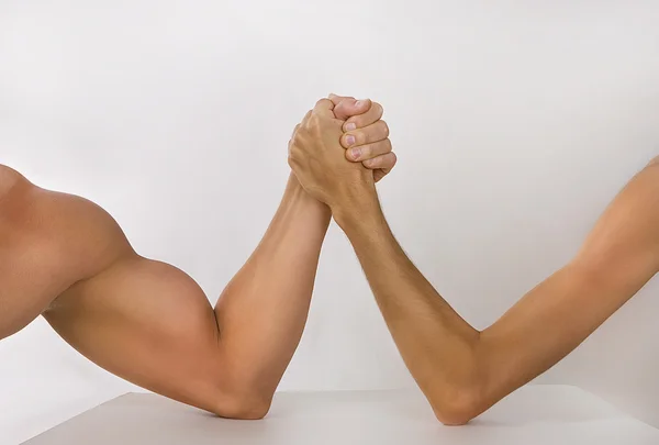 Two hands clasped arm wrestling (strong and weak), Unequal match — Stock Photo, Image