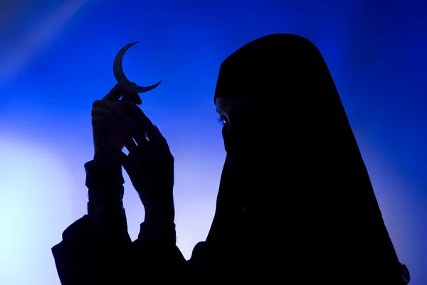 Dark silhouette: Beautiful muslim girl holding a moon symbol, sp — Stock Photo, Image