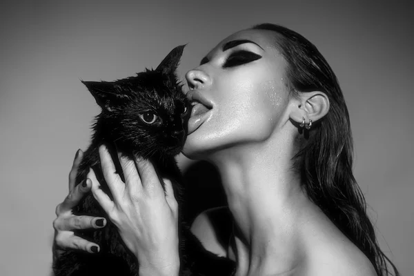 Beautiful Sexy Woman with Glamour make-up licking a cat. Fashion — Stock Photo, Image