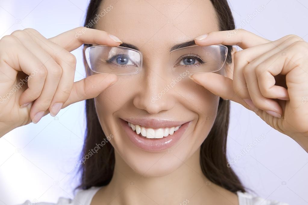 Optics and Glasses, Portrait of young smiling woman looking thro