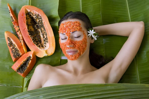 Mooie vrouw met verse papaya gezichtsmasker van toepassing. verse pap — Stockfoto