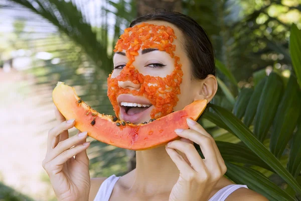 Vacker kvinna med papaya facial mask tillämpas. Hälsosam mat — Stockfoto