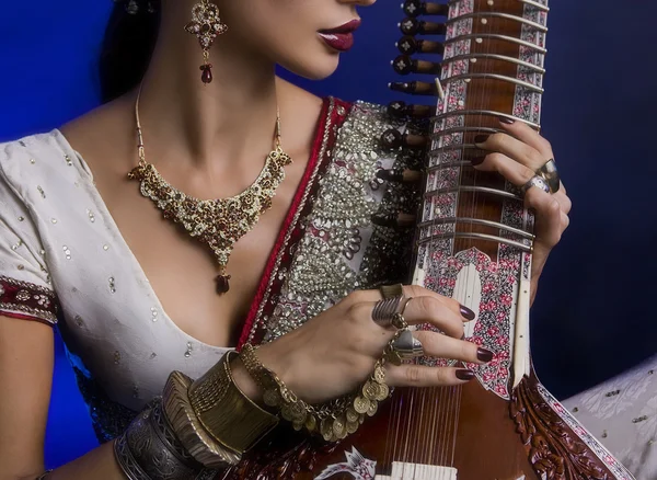 Schöne indische Frau in Sari mit orientalischem Schmuck spielt die — Stockfoto