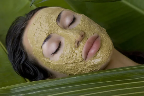 Woman with green herbal clay facial mask, beauty spa. — Stok fotoğraf