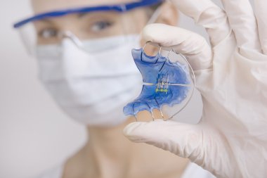 Hizmetli dişler, yakın çekim için tutarak diş hekimi