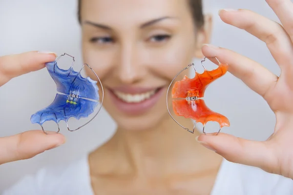 Hermosa chica sonriente con retenedor para los dientes, primer plano —  Fotos de Stock