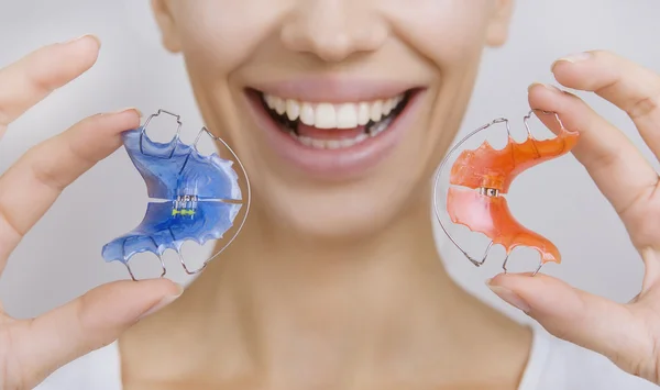 Hermosa chica sonriente con retenedor para los dientes, primer plano —  Fotos de Stock