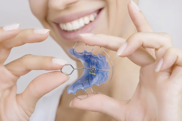 Hermosa chica sonriente con retenedor para los dientes, primer plano — Foto de Stock