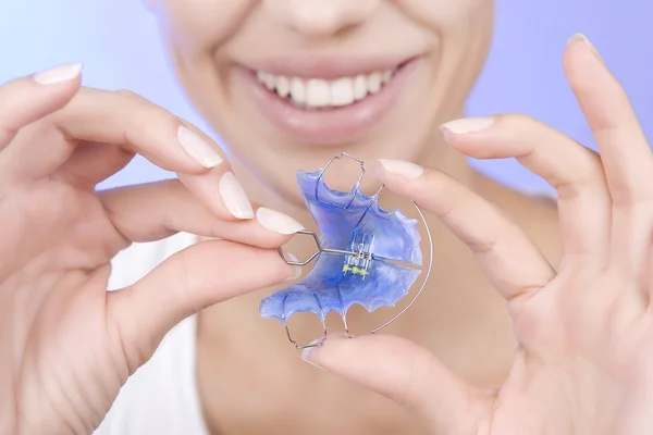 Hermosa chica sonriente con retenedor para los dientes, primer plano —  Fotos de Stock