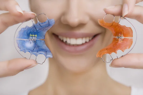 Mooi lachende meisje met retainer voor tanden, close-up — Stockfoto