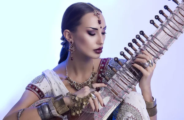 Όμορφη indian γυναίκα sari με ανατολίτικα κοσμήματα παίζει το — Φωτογραφία Αρχείου