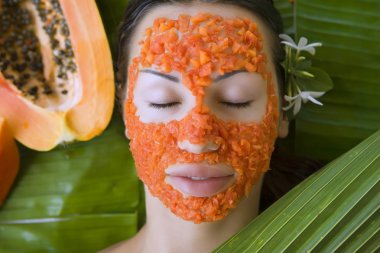 taze papaya yüz maskesi uygulamak olan güzel bir kadın. taze pap