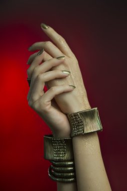 Altın manikür, parlak altın oje ile eller