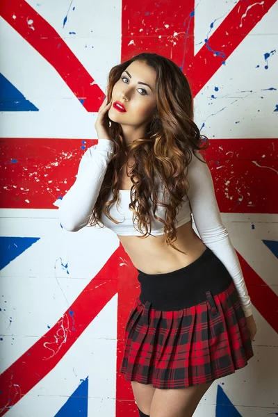 Beautiful Cute young Woman posing with the UK Flag in the backgr — Stock Photo, Image